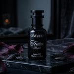 Elwane Tonka Royale perfume bottle on a dark surface with purple flowers.