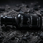 Elvare Oud Feathers perfume bottle on a dark, textured surface